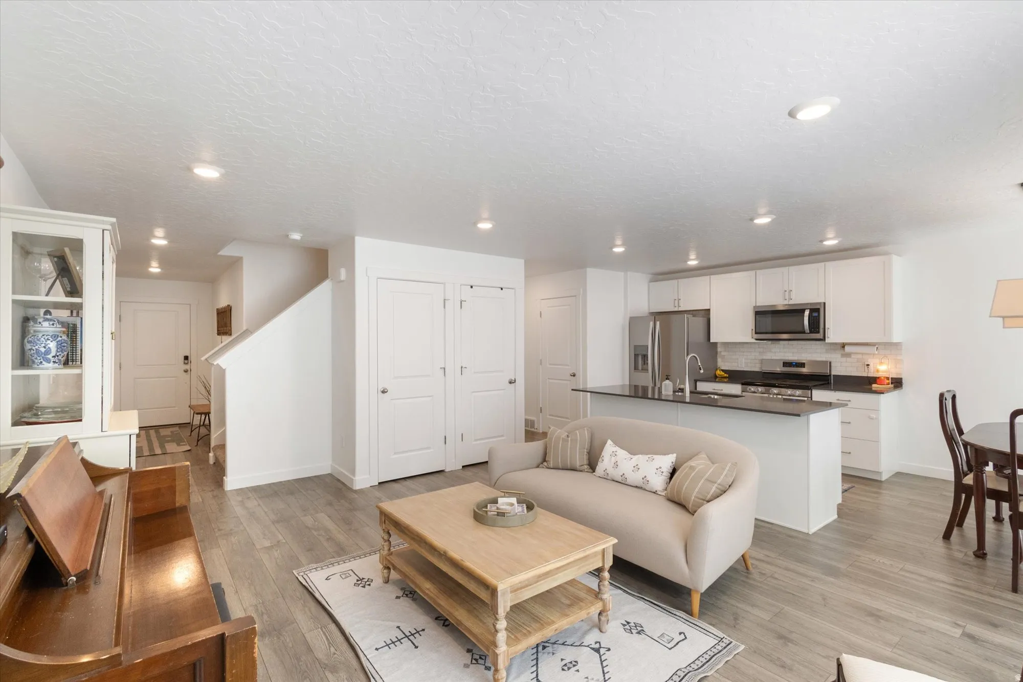 Living room featuring light wood-style flooring and a textured ceiling