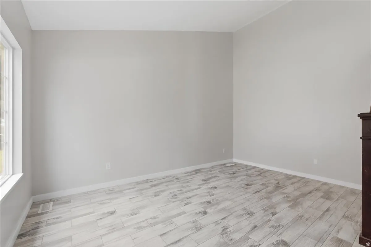 Unfurnished room featuring light wood-type flooring and baseboards