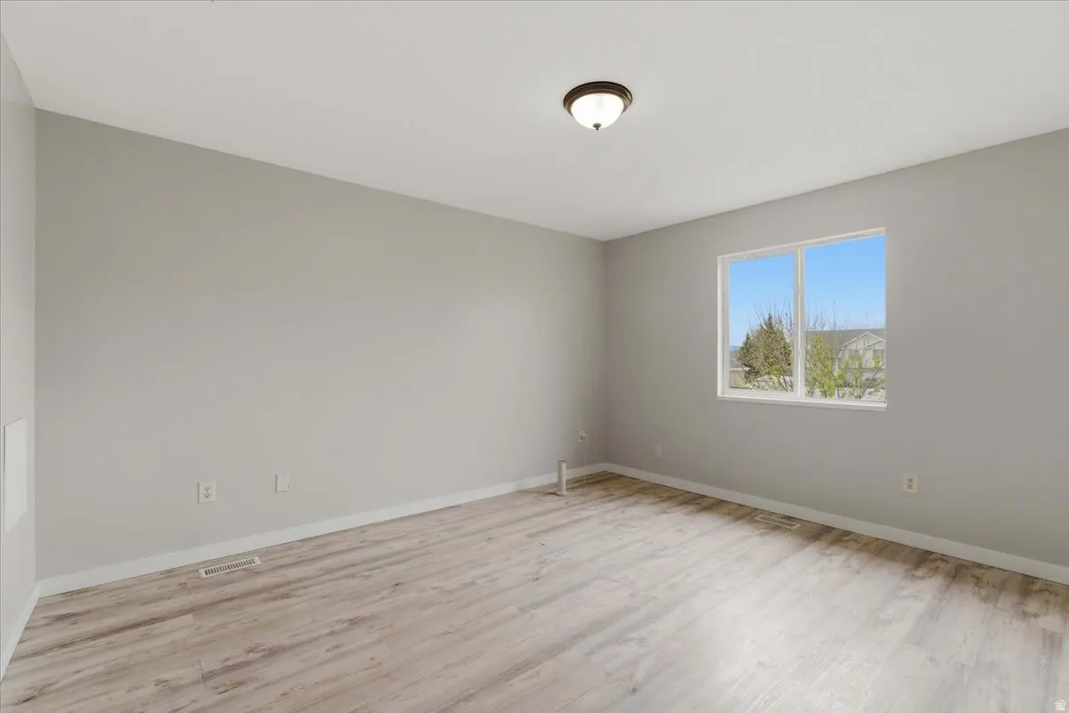 Spare room with light wood-style floors and baseboards