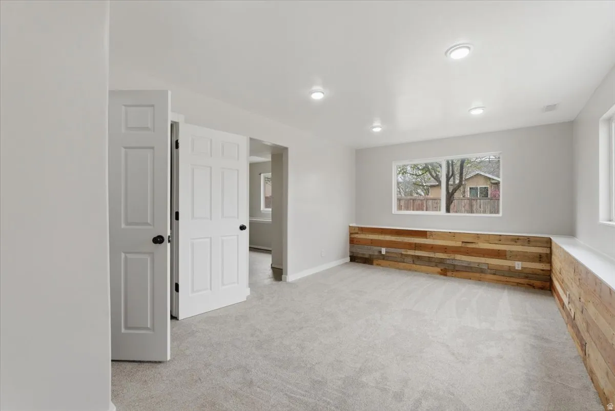 Spare room featuring light carpet and baseboards