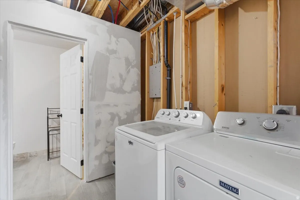 Laundry area with washing machine and dryer and light wood-style floors