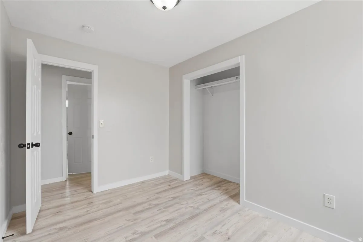 Unfurnished bedroom with light wood-style flooring and a closet
