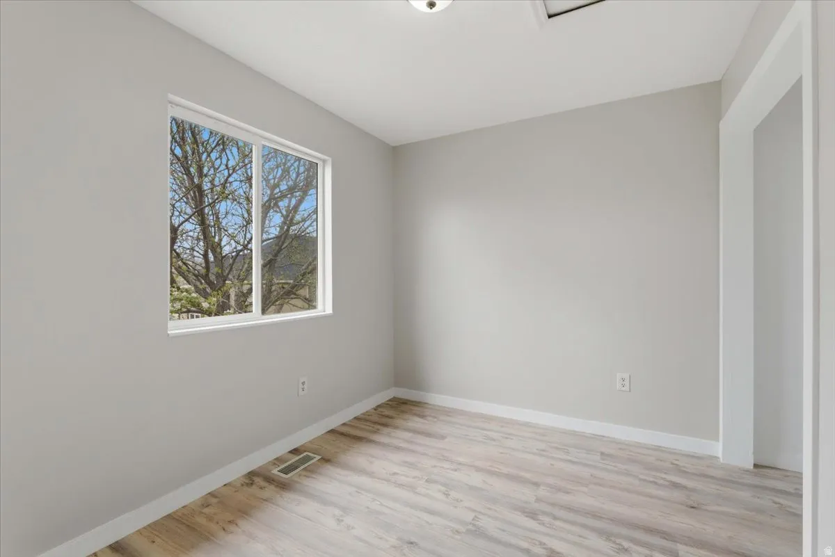 Spare room featuring light wood-style floors and baseboards
