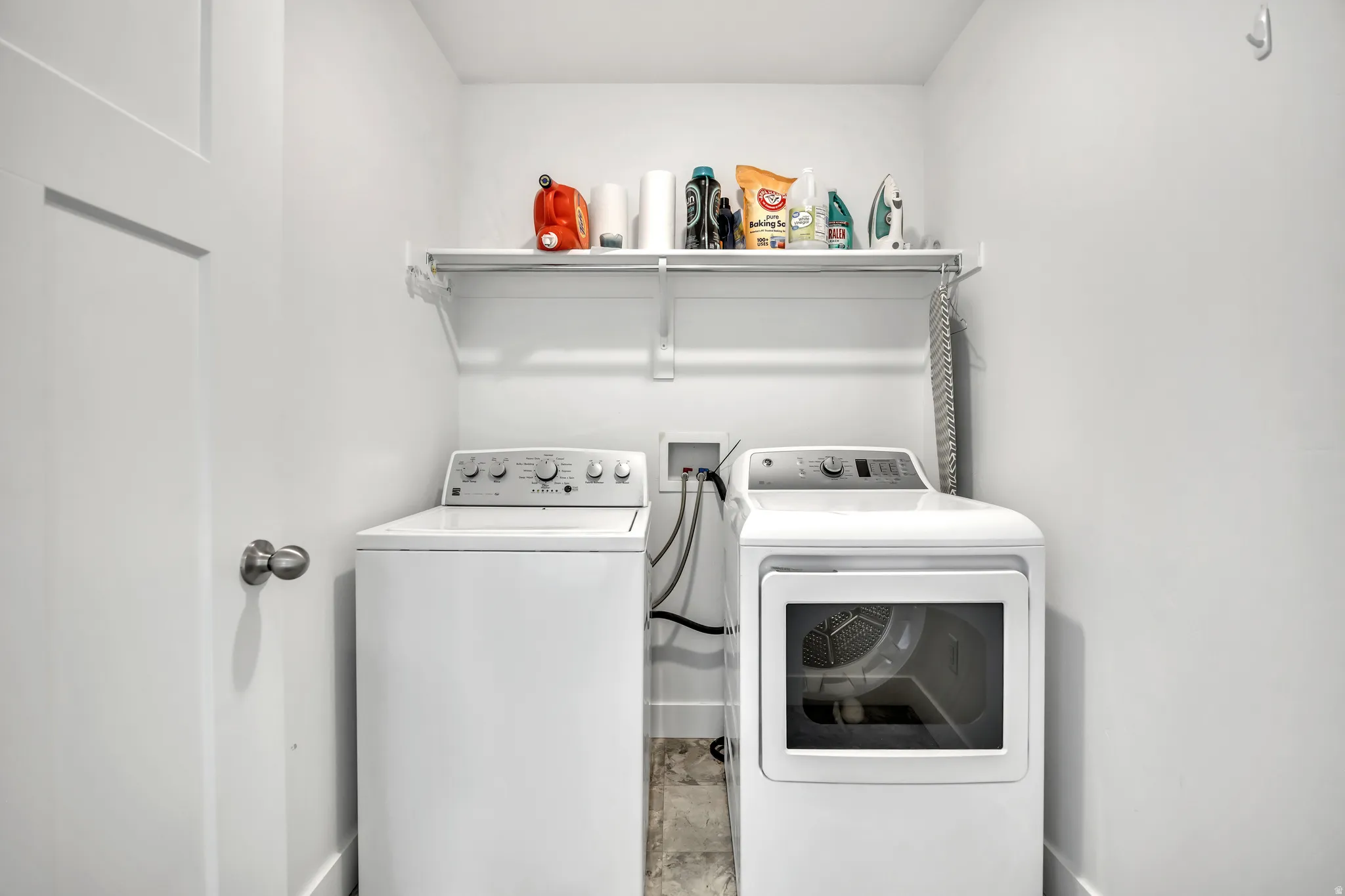 Laundry room featuring washing machine and dryer and baseboards