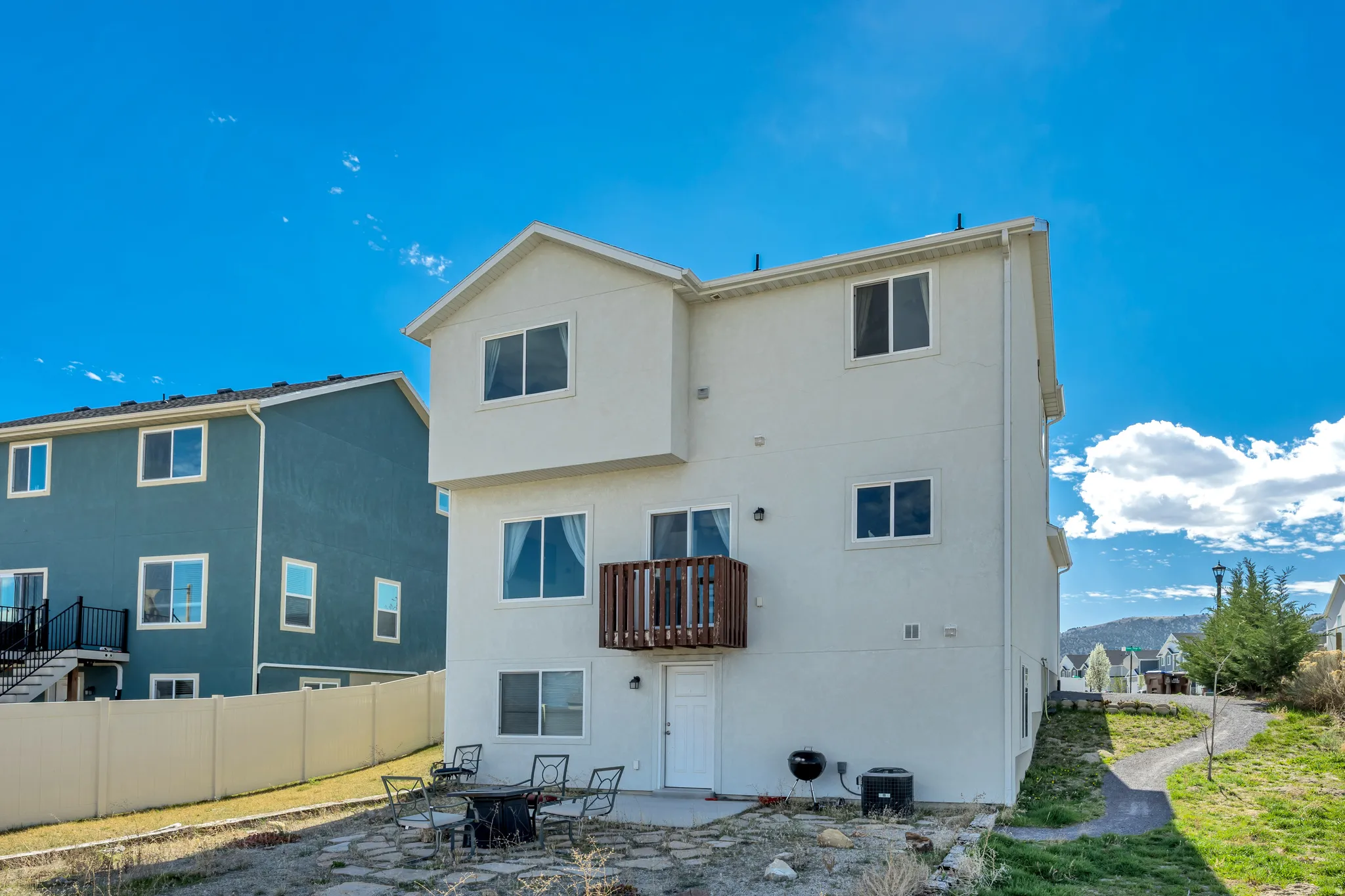 Rear view of property with a patio area, stucco siding, and a balcony