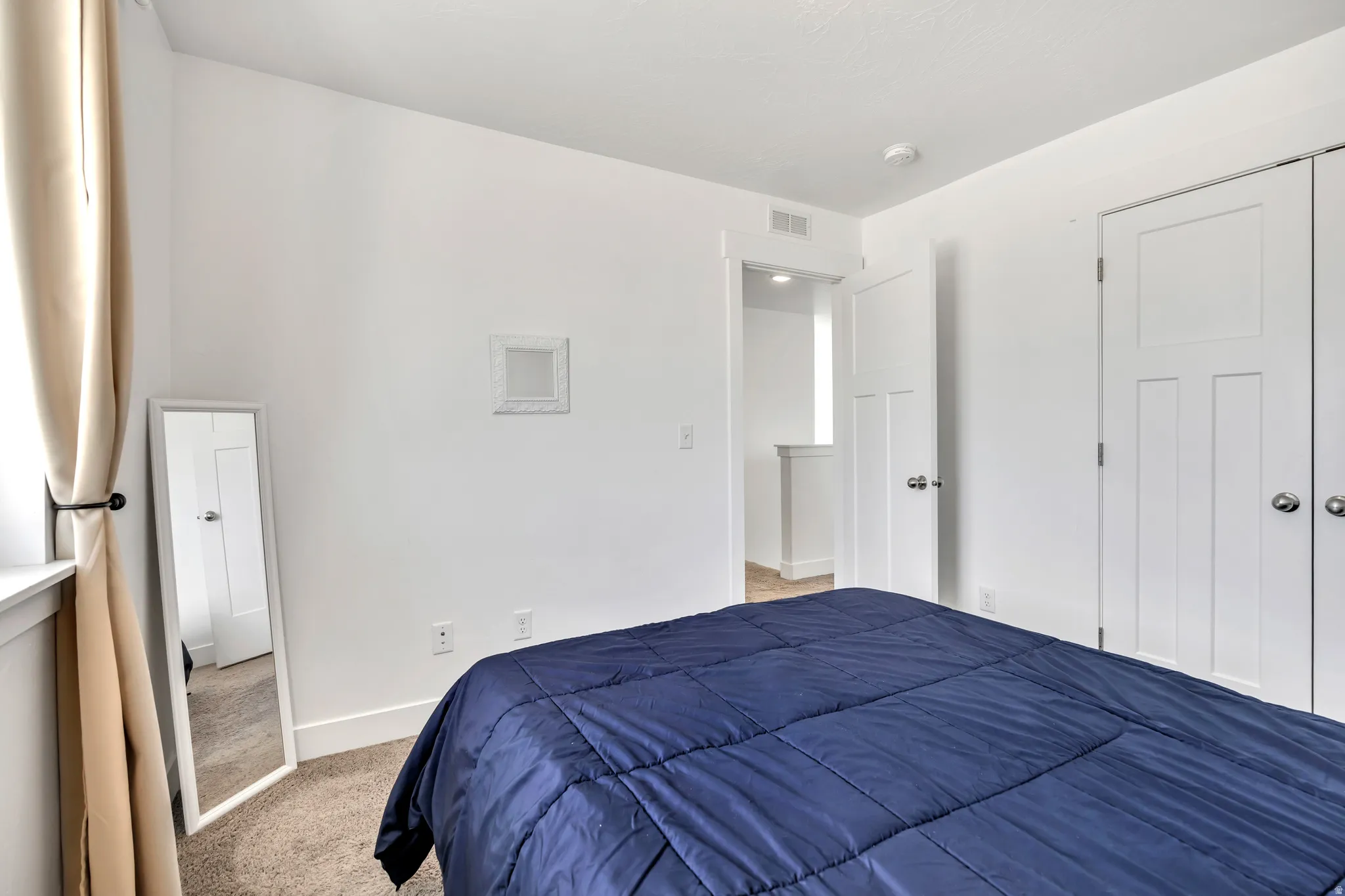 Bedroom featuring light colored carpet and a closet