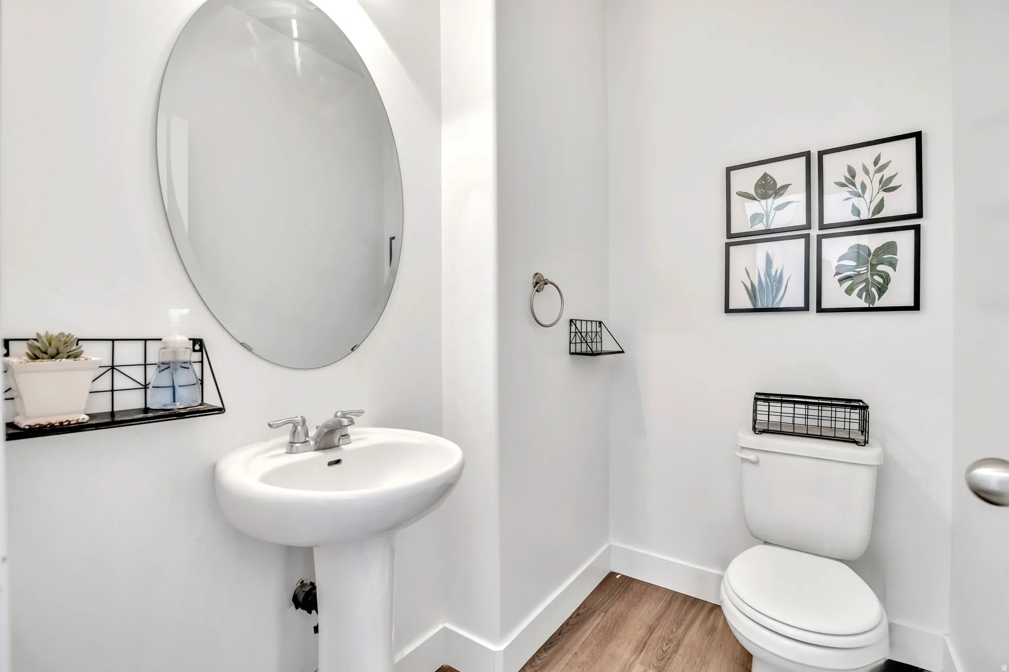 Half bath with light wood-style flooring and toilet