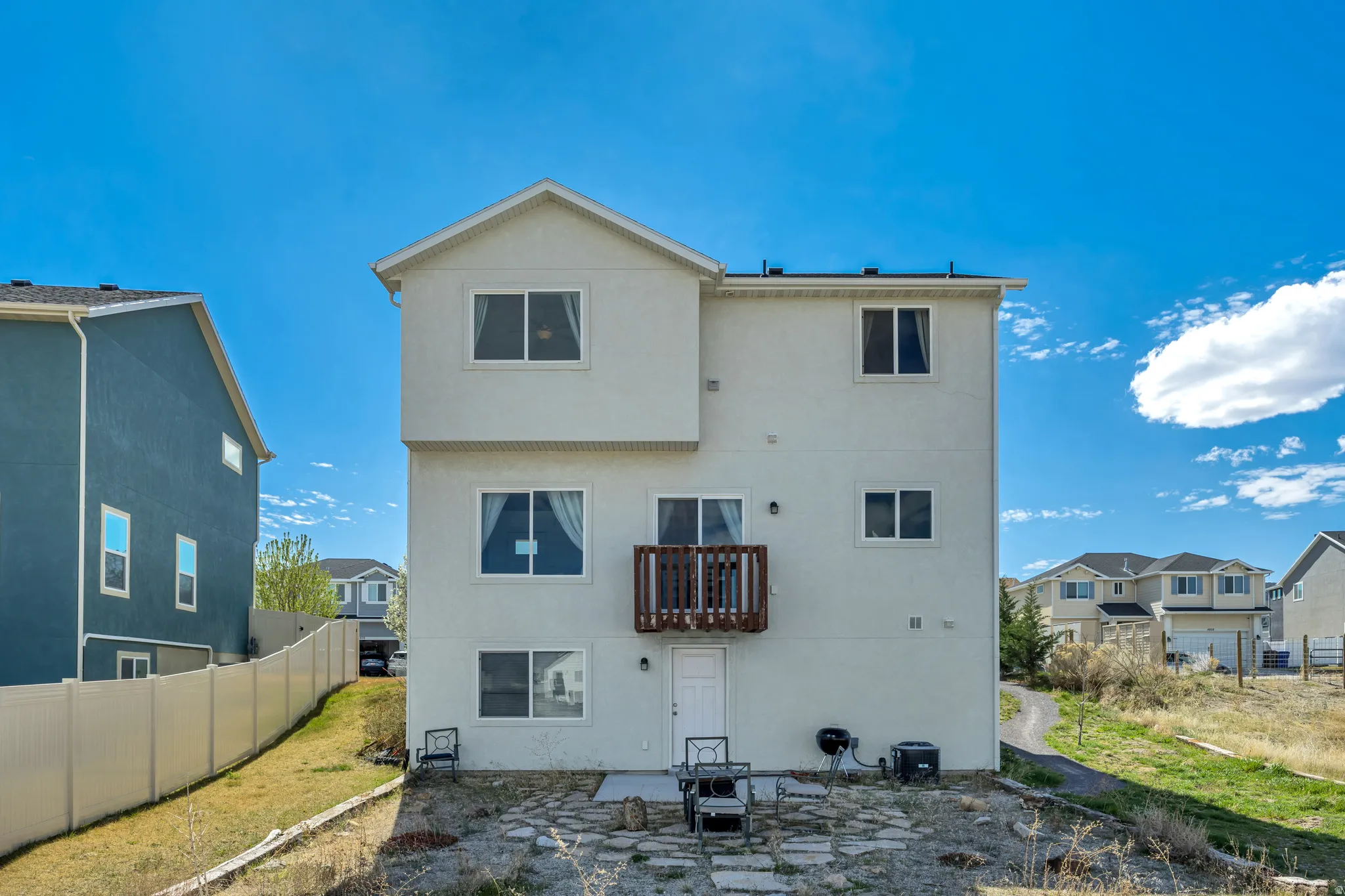 Rear view of house featuring a patio, stucco siding, and a residential view