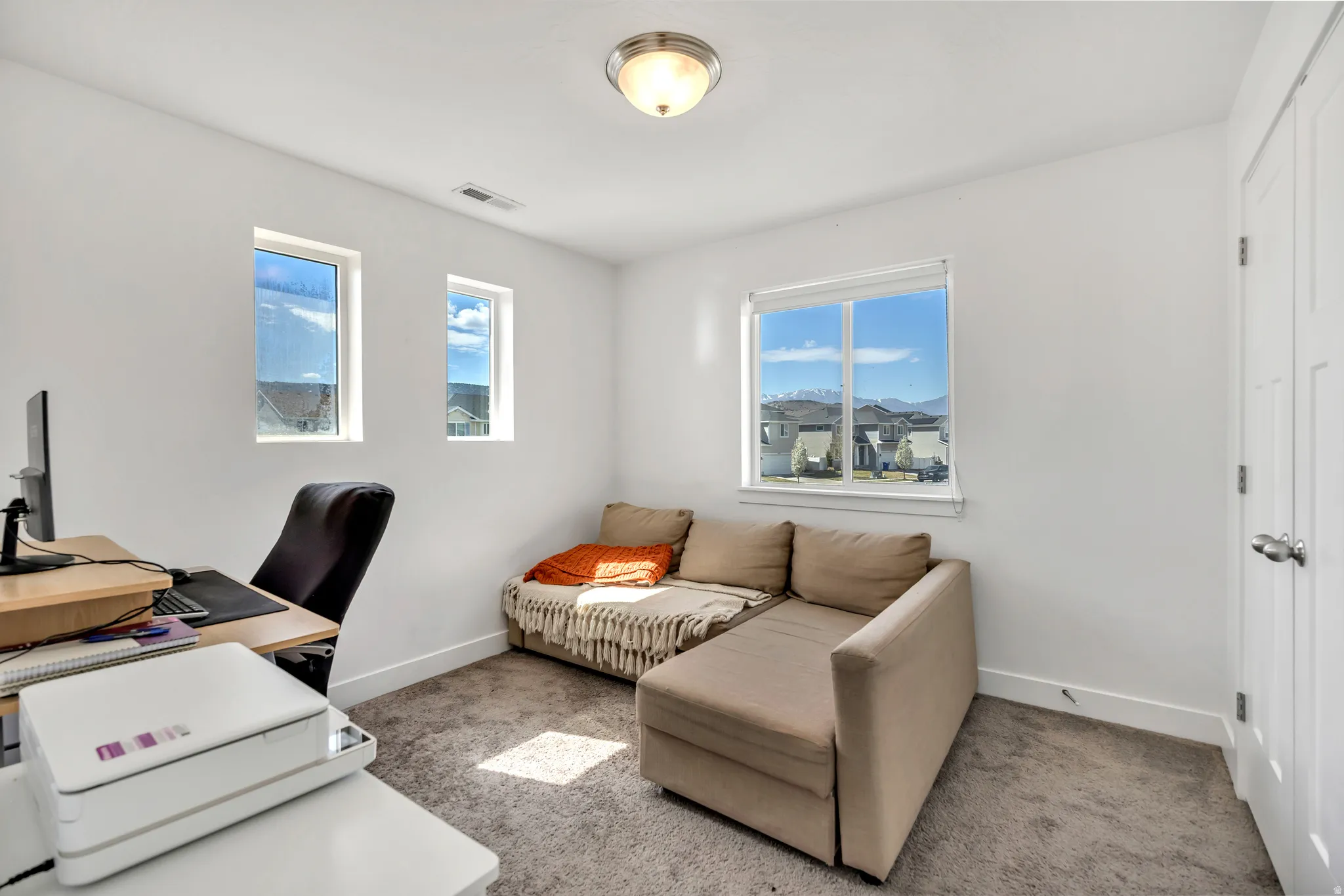 Office space with baseboards and light carpet