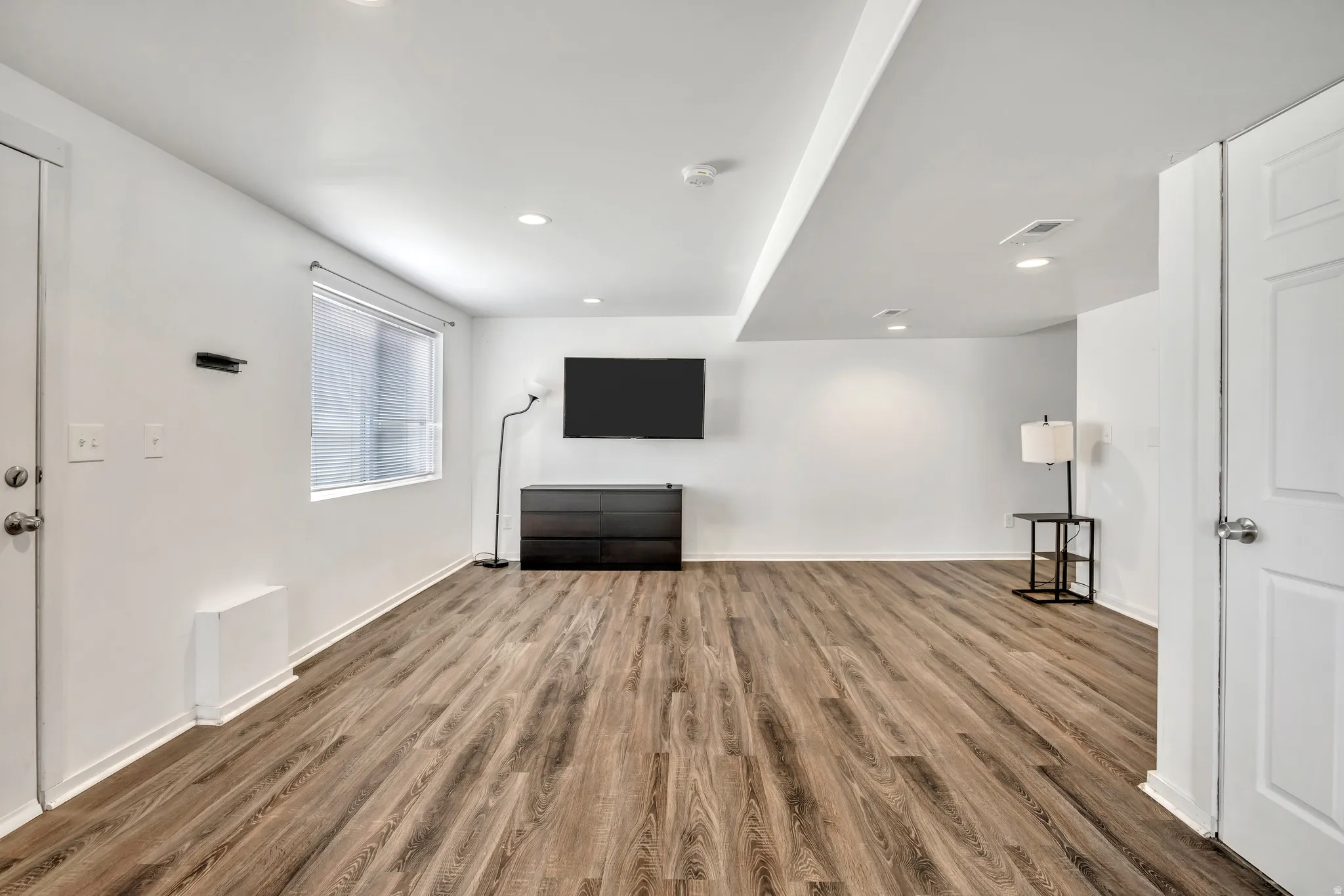 Unfurnished living room featuring dark wood finished floors and recessed lighting