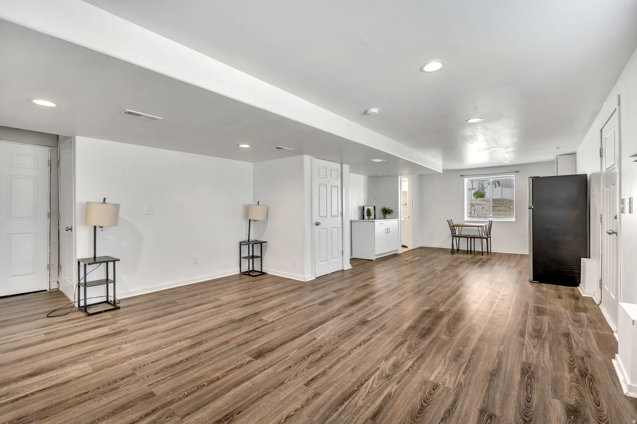 Unfurnished living room featuring dark wood-style flooring and recessed lighting