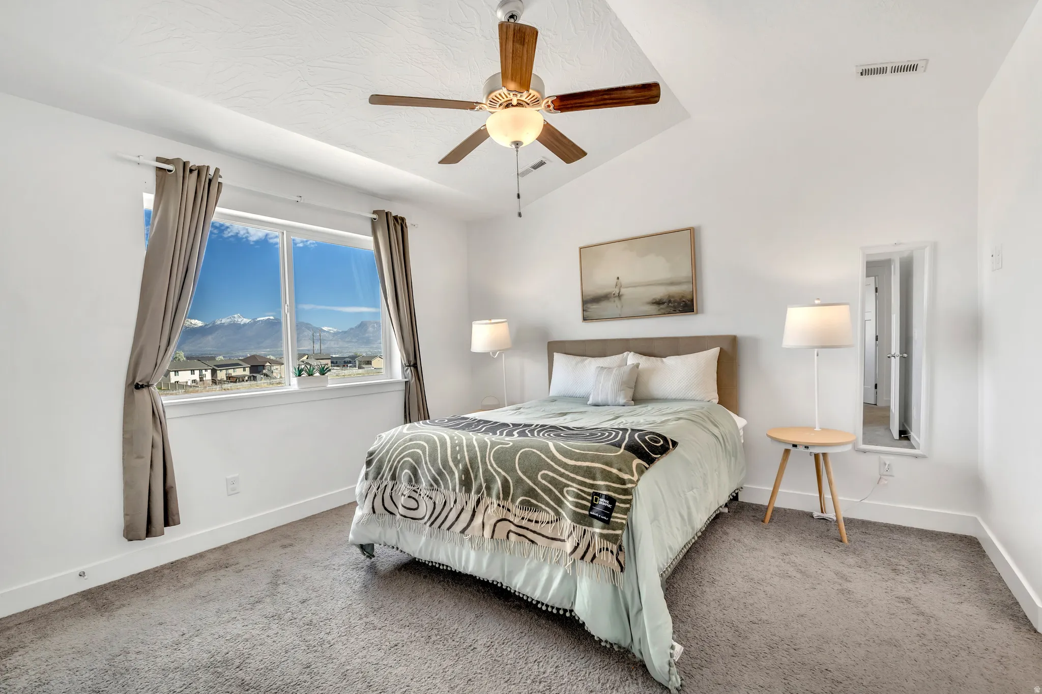 Bedroom with a mountain view, carpet, vaulted ceiling, and ceiling fan