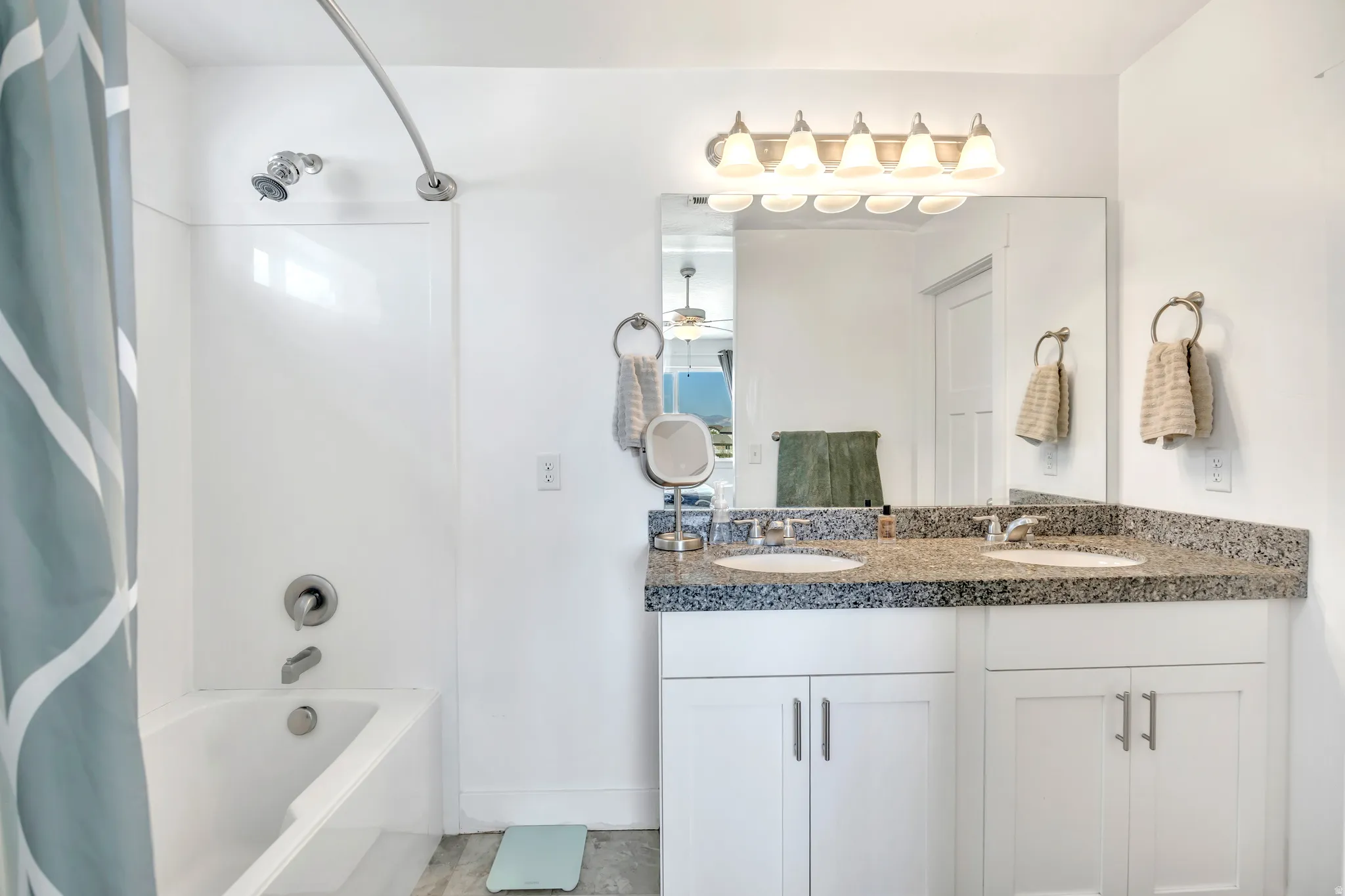 Full bath featuring double vanity and shower / tub combo with curtain
