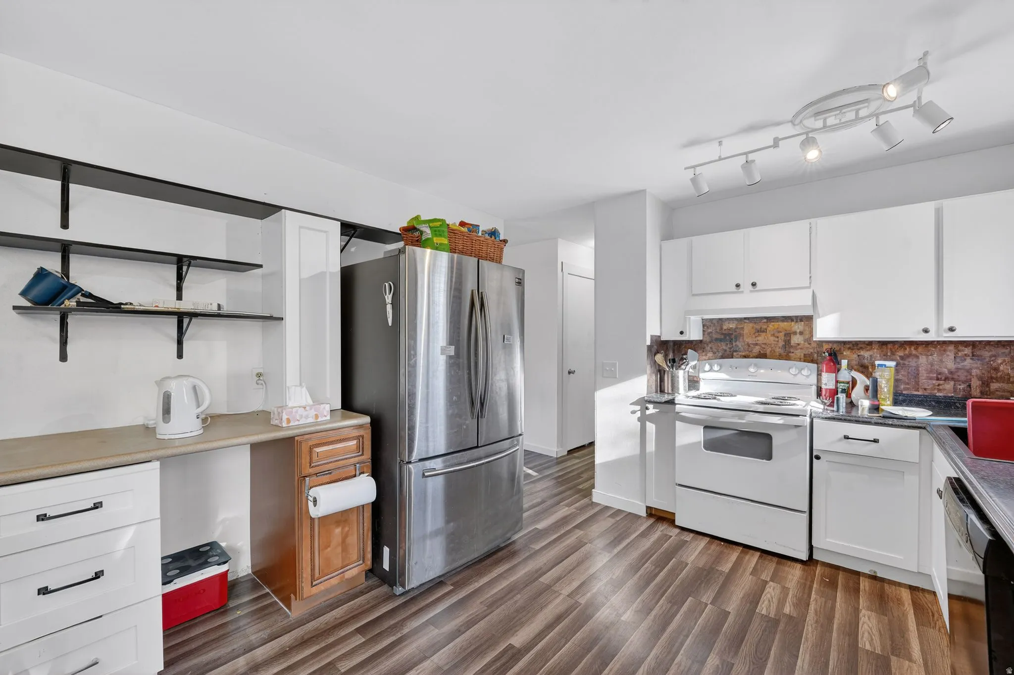 Kitchen featuring white cabinets, freestanding refrigerator, electric stove, and open shelves