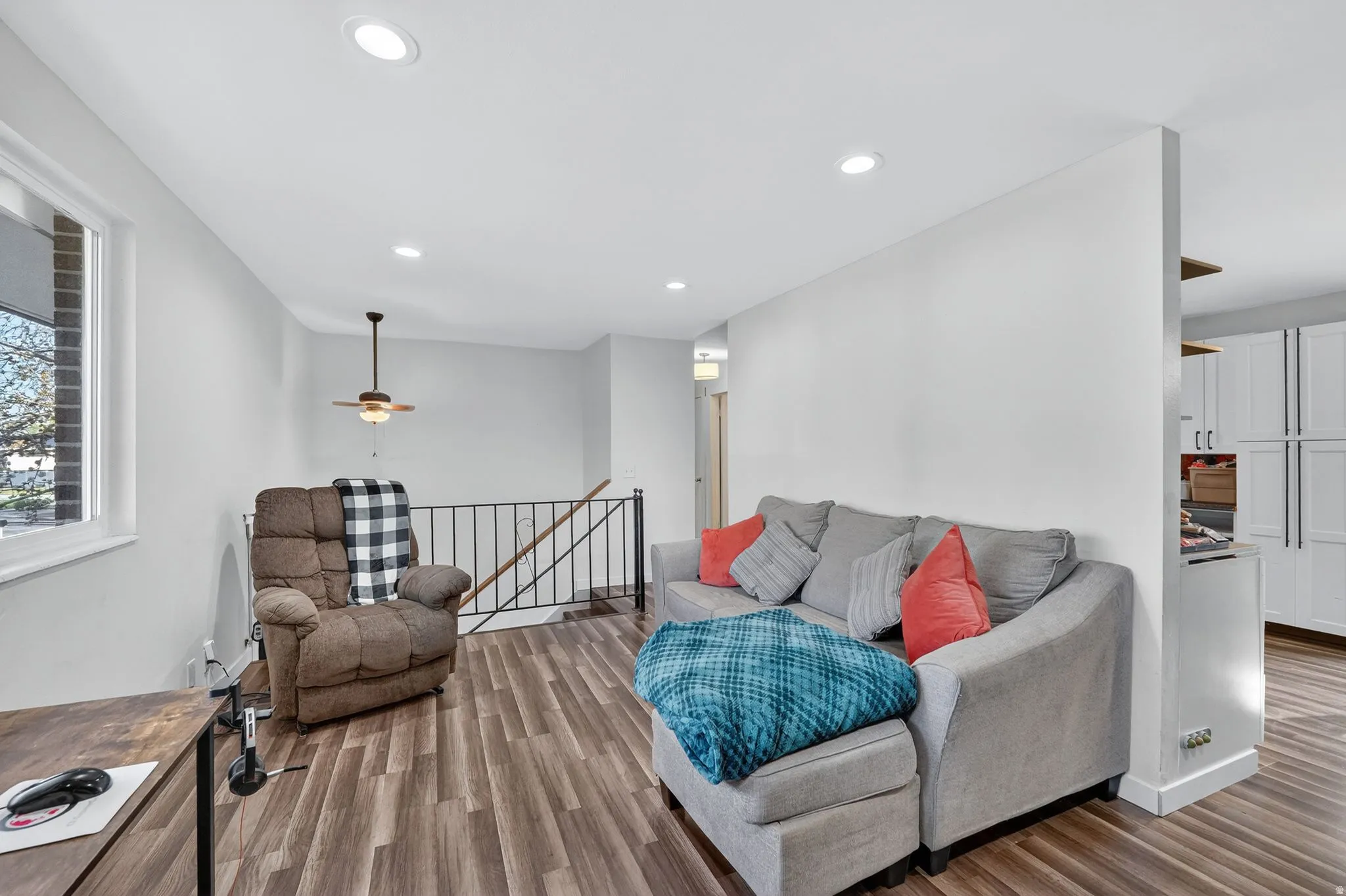 Living area with laminate finished floors and recessed lighting