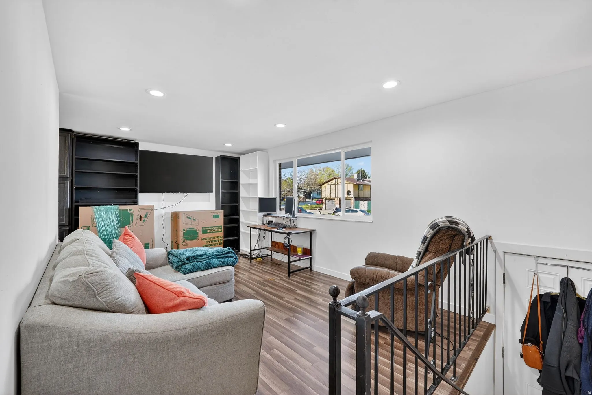 Living room featuring recessed lighting, and laminate finished floors.