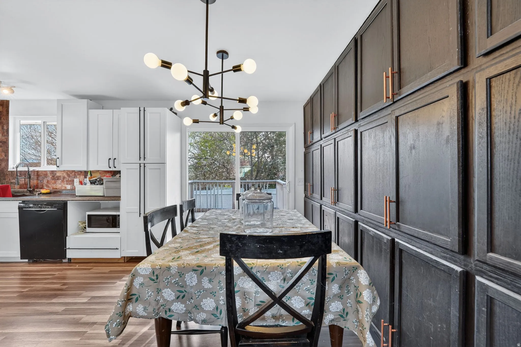Dining space with hanging lights, light wood-style floors, and healthy amount of natural light
