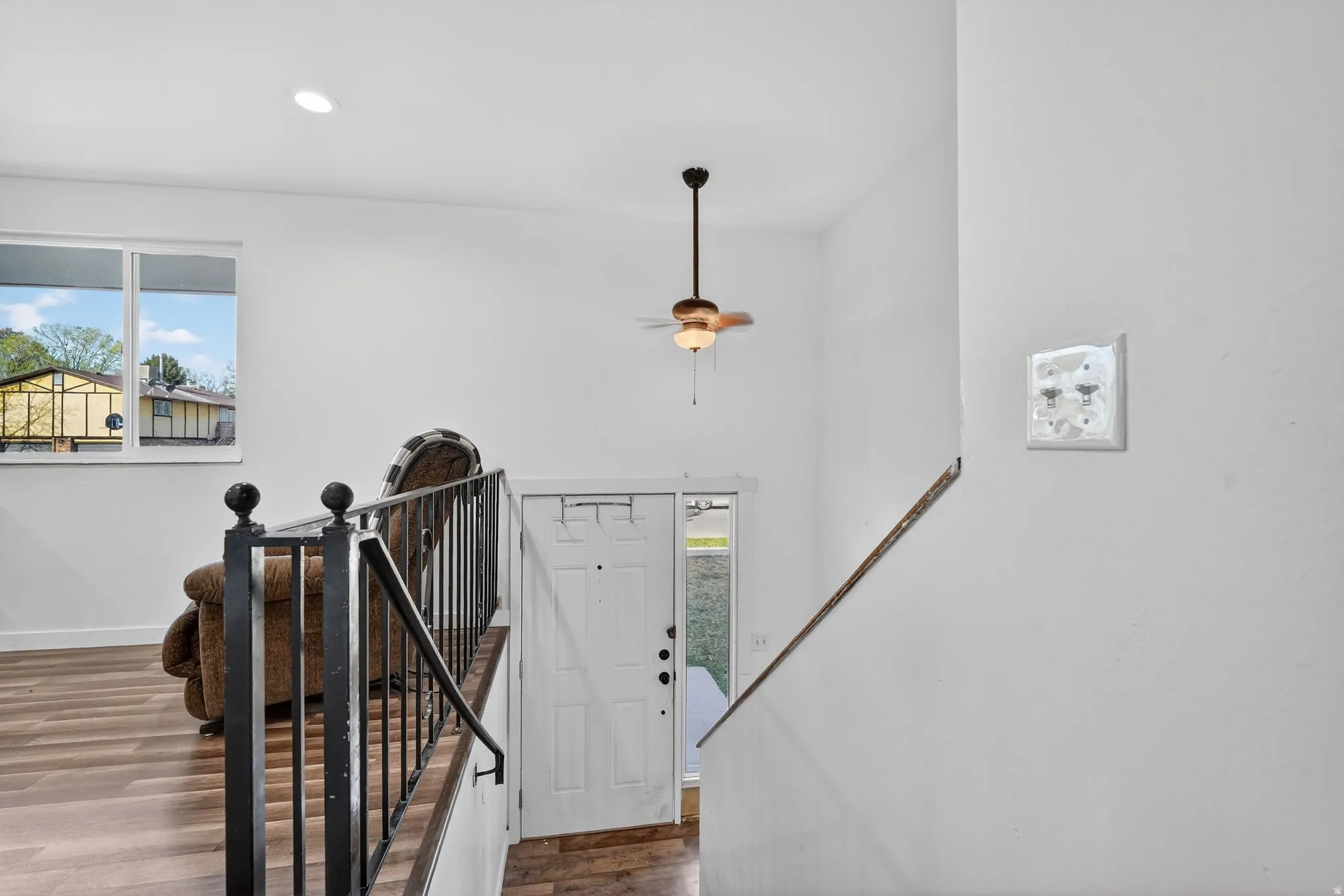 Staircase with plenty of natural light, wood finished floors, and recessed lighting