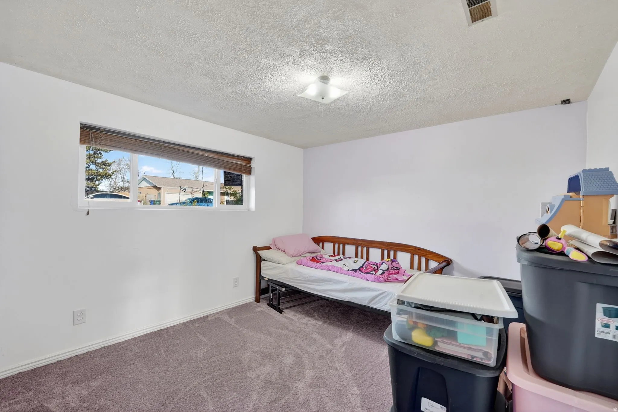 Carpeted bedroom with a textured ceiling