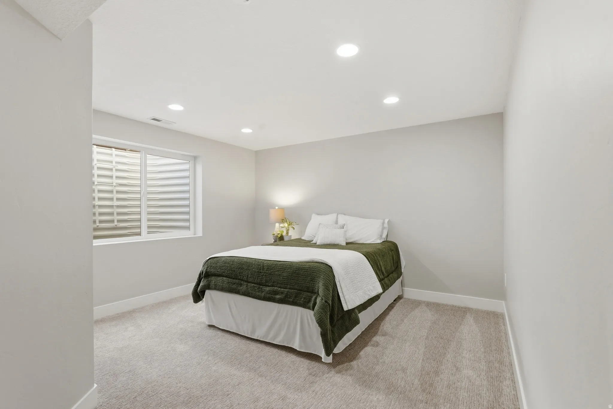 Bedroom with light carpet and recessed lighting
