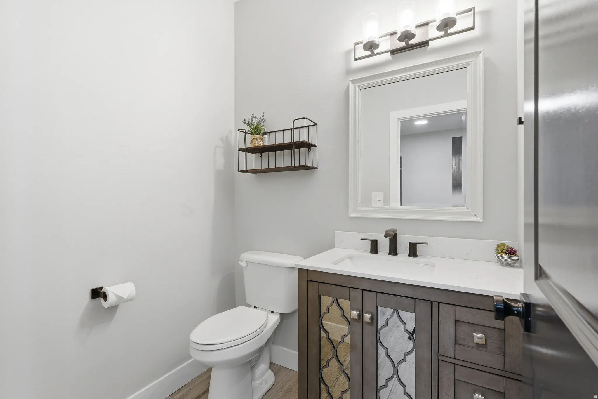 Half bathroom on main level with vanity and light wood finished floors