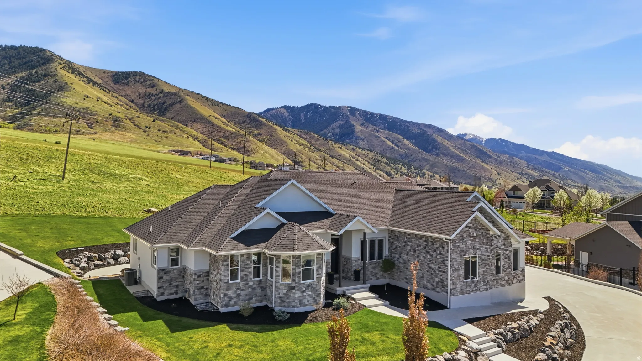 View of front of home with stone siding, front lawn and mountain view