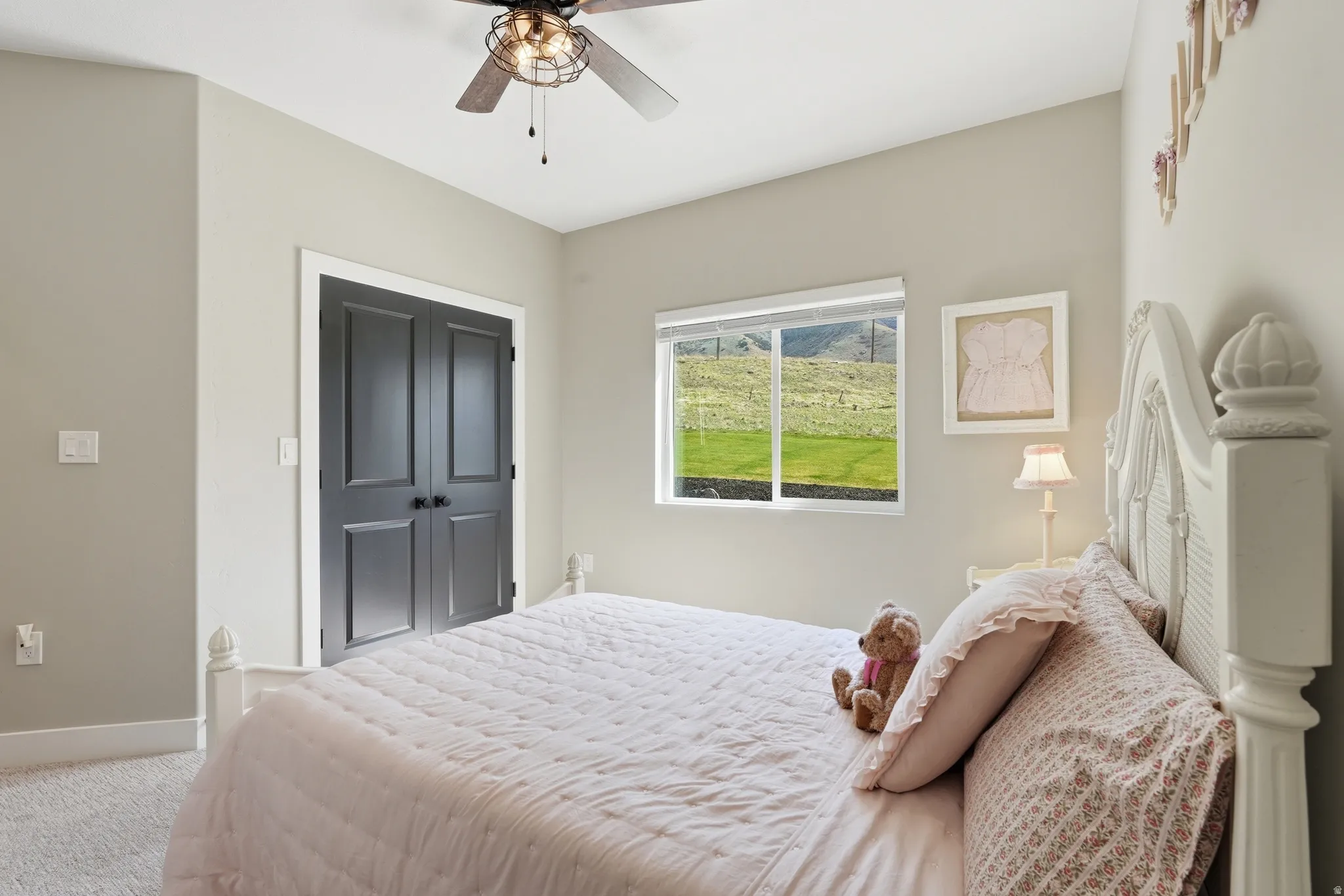 Carpeted bedroom with a ceiling fan and a closet