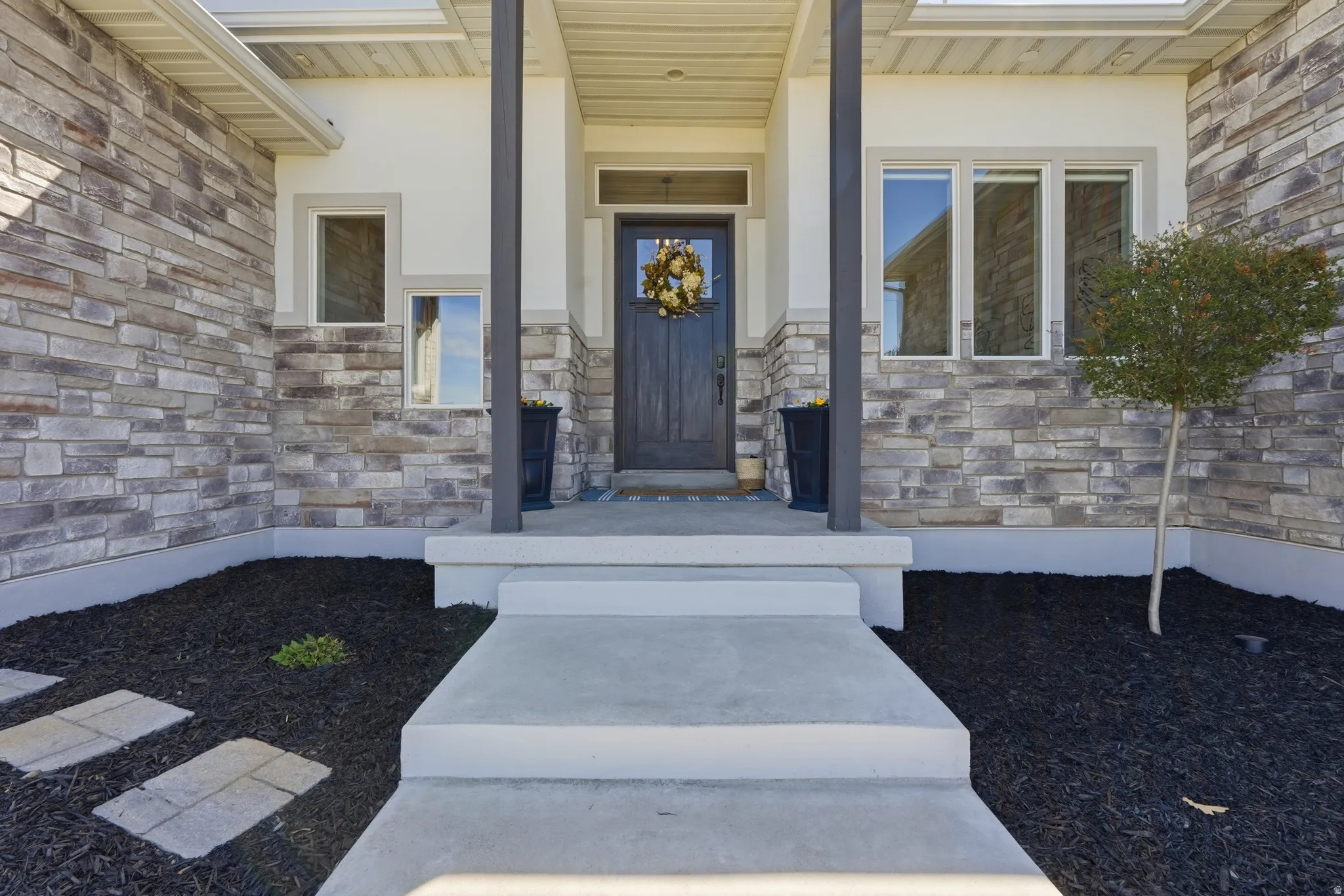 Property entrance with a porch and stucco siding