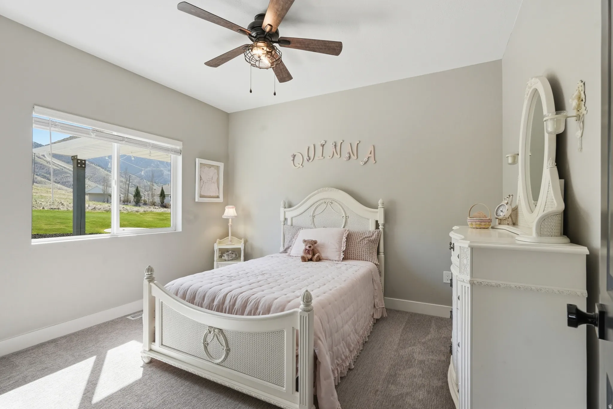Carpeted bedroom with a mountain view and a ceiling fan