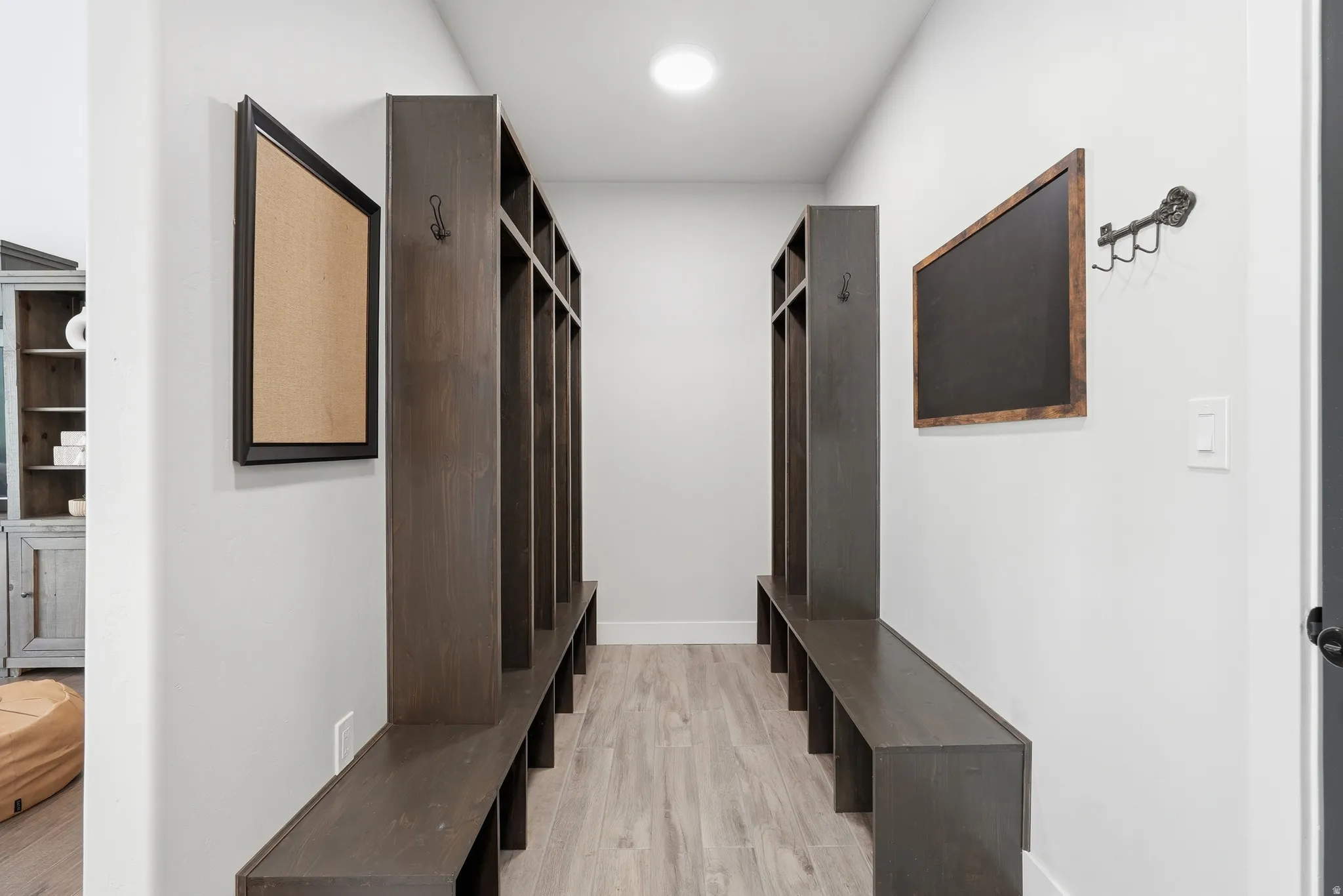 Mudroom featuring light wood-style flooring and baseboards