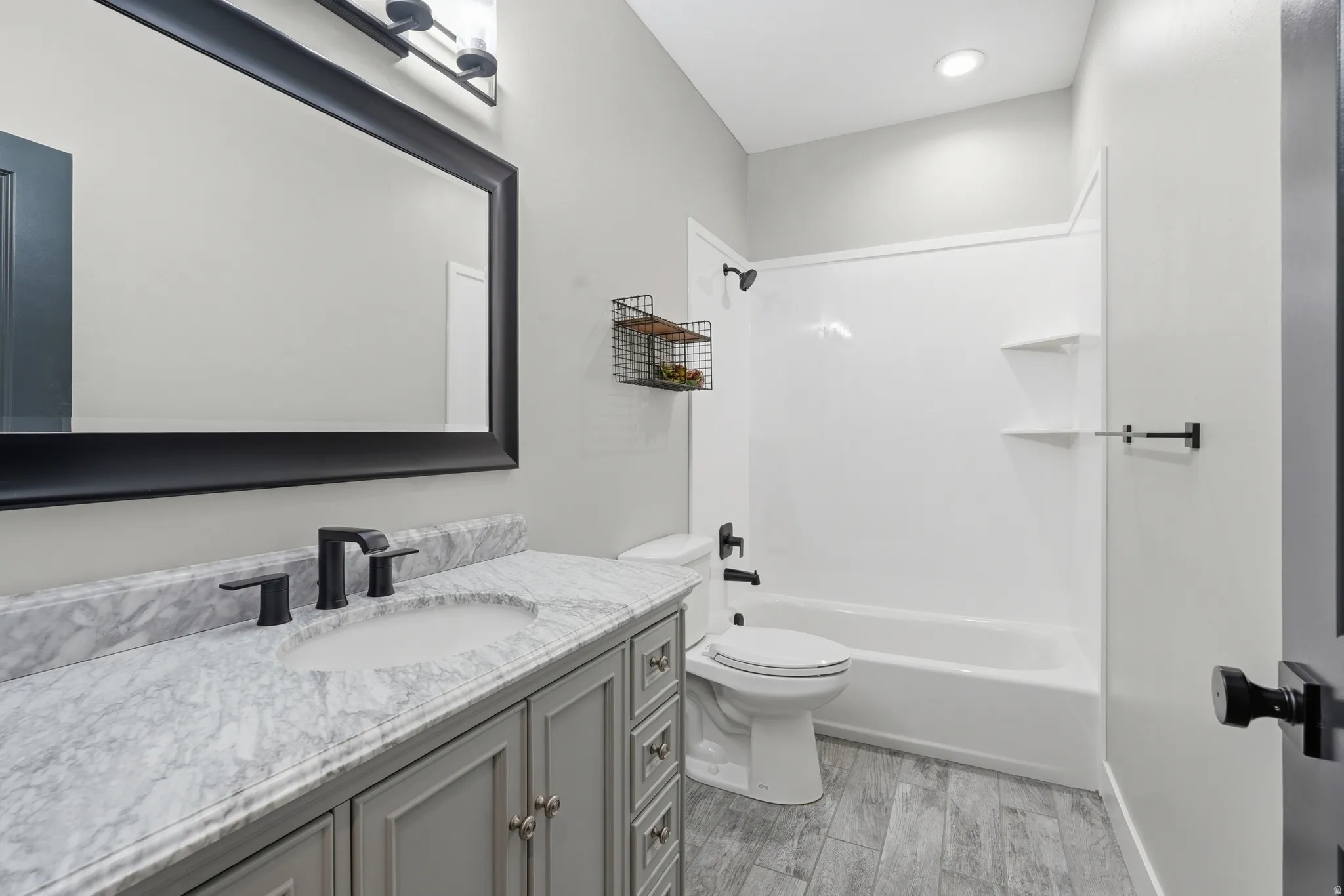 Full bath featuring vanity, light wood finished floors, and  shower combination