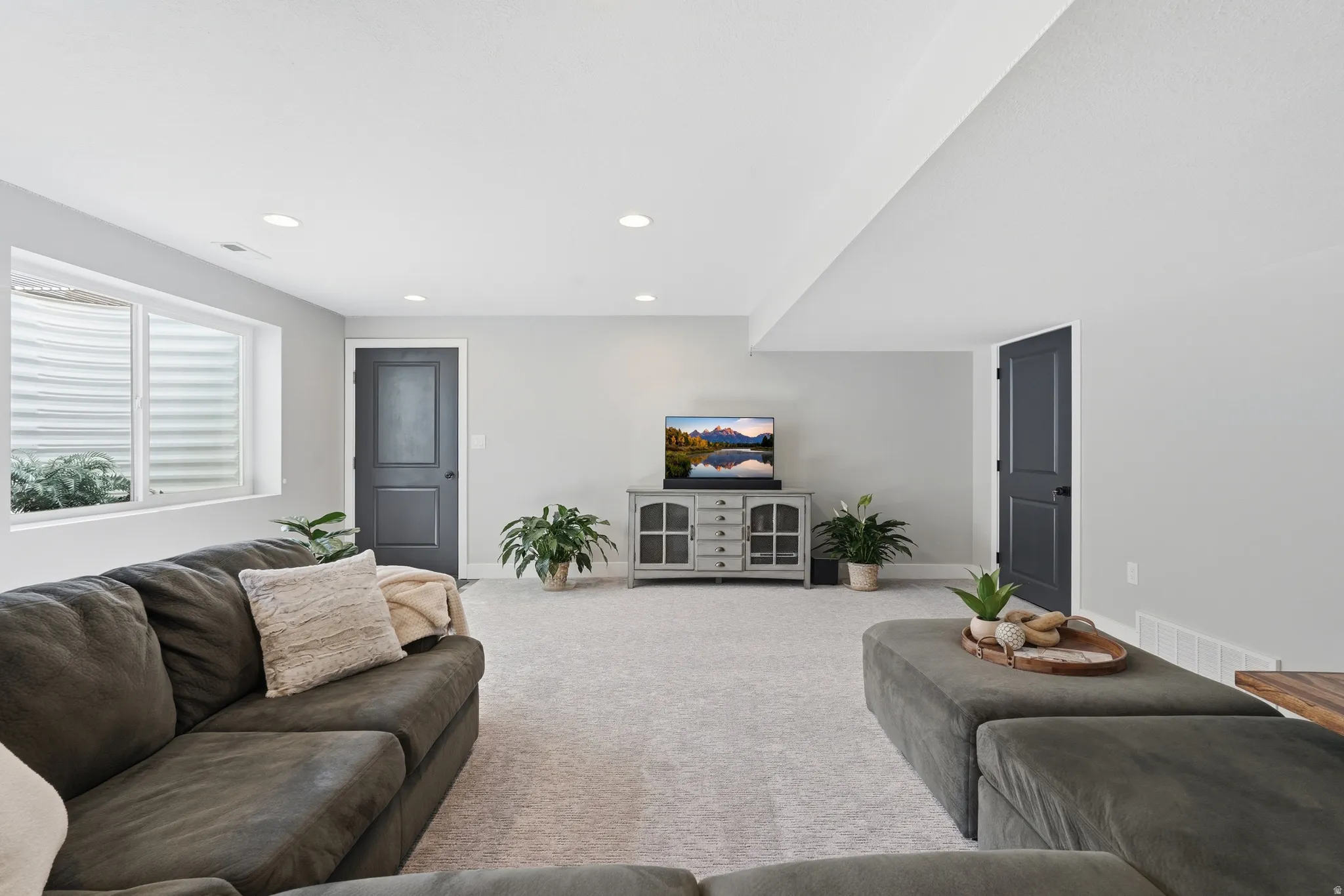 Carpeted living area with recessed lighting and baseboards