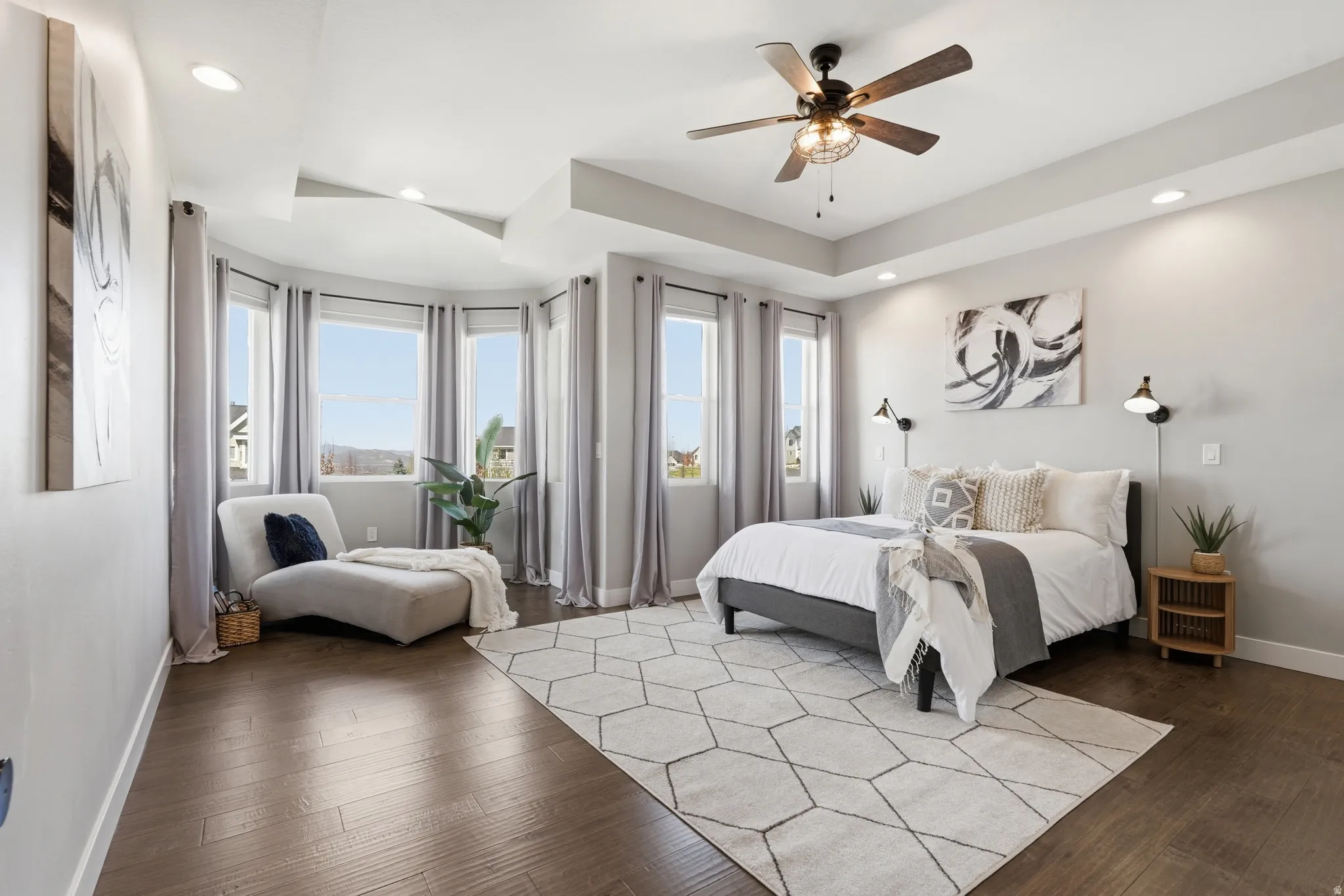 Primary bedroom with hardwood flooring, sitting area, a ceiling fan, and recessed lighting