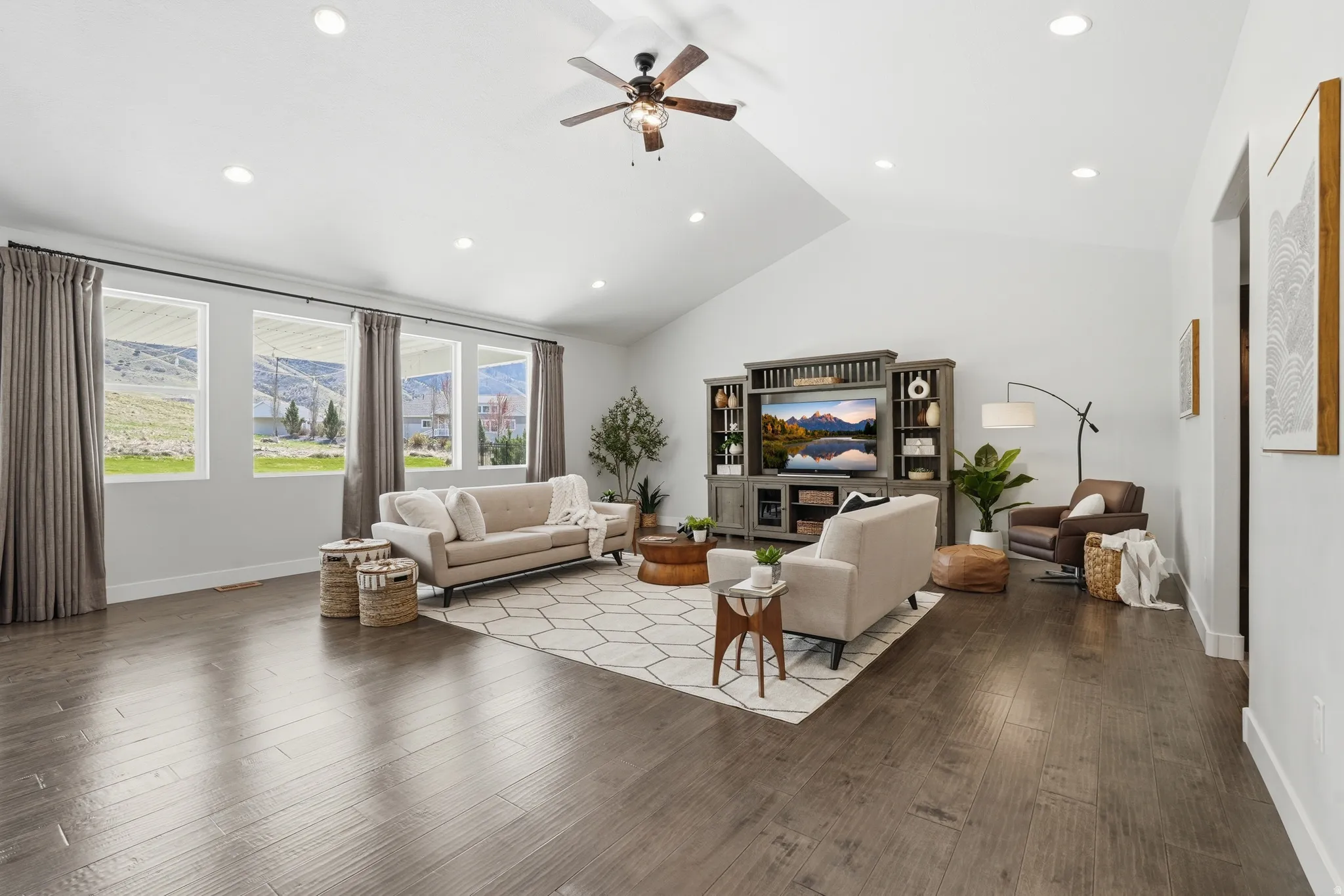 Living room with a ceiling fan, wood-type flooring, lofted ceiling, a mountain view, and recessed lighting