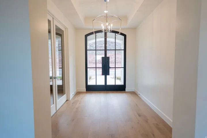 Doorway to outside with a chandelier, french doors, hardwood / wood-style flooring, and a tray ceiling