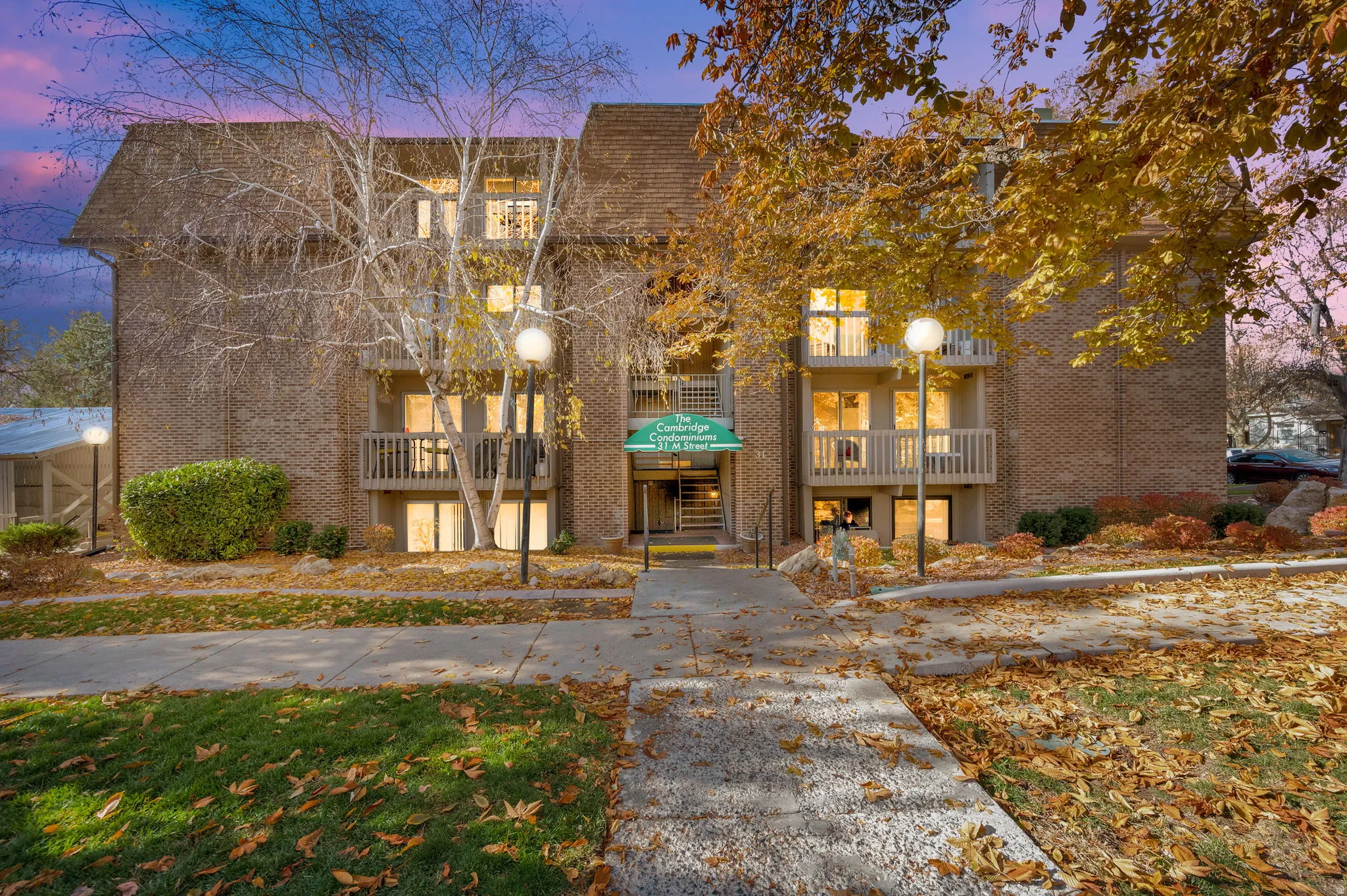 Property at dusk featuring a view of apartment building / complex