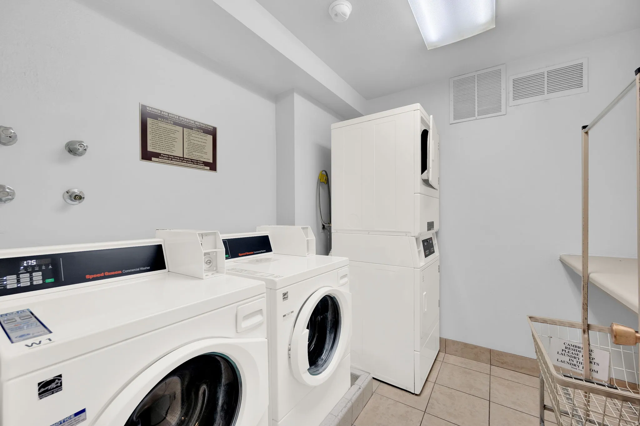 Community laundry room with washing machine and clothes dryer