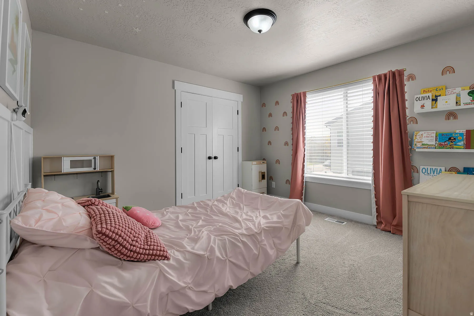 Bedroom featuring light colored carpet, a textured ceiling, and a closet