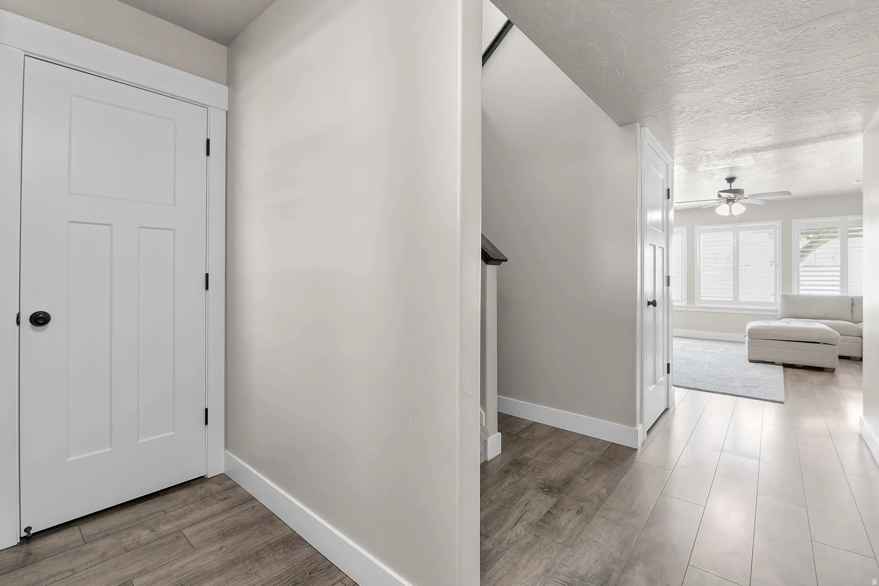 Hall featuring light wood finished floors and a textured ceiling