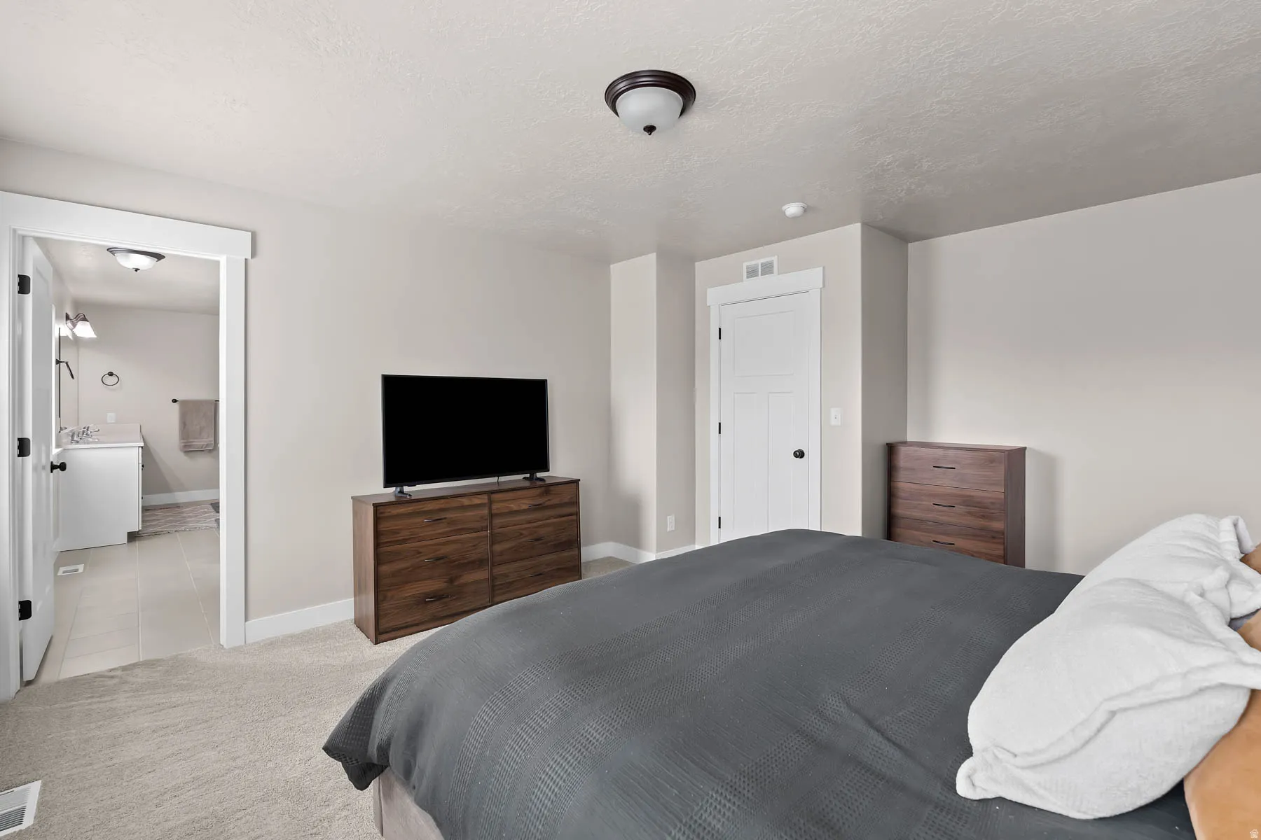 Bedroom featuring carpet floors, a textured ceiling, and tile patterned flooring