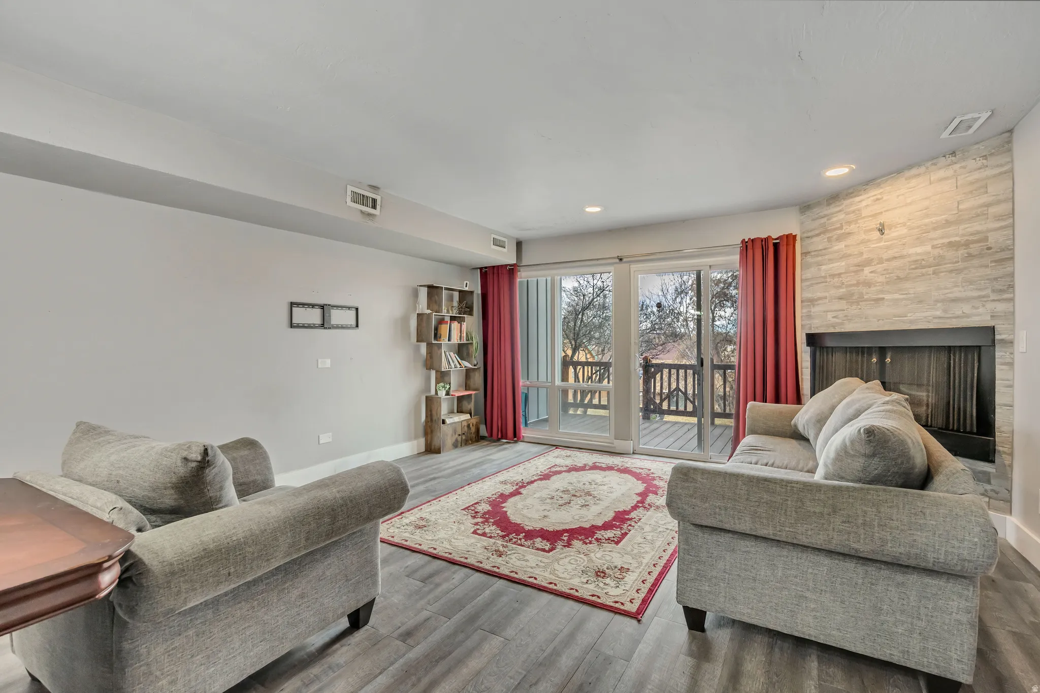 Living area featuring wood finished floors, a large fireplace, and recessed lighting