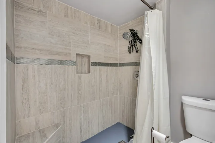 Full bathroom with a stall shower and toilet