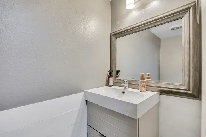 Bathroom with vanity and a textured wall