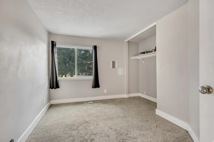Empty room featuring light carpet and a textured ceiling