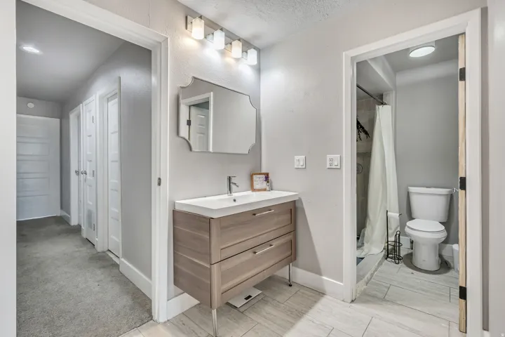 Bathroom with a shower stall, vanity, a textured wall, and a textured ceiling
