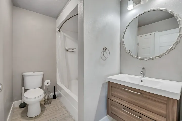 Bathroom with vanity, shower / bath combination with curtain, and light wood-type flooring
