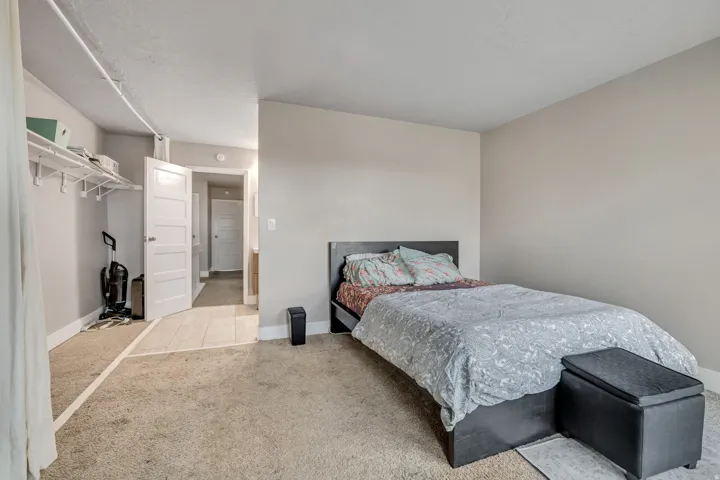 Bedroom featuring light carpet and baseboards
