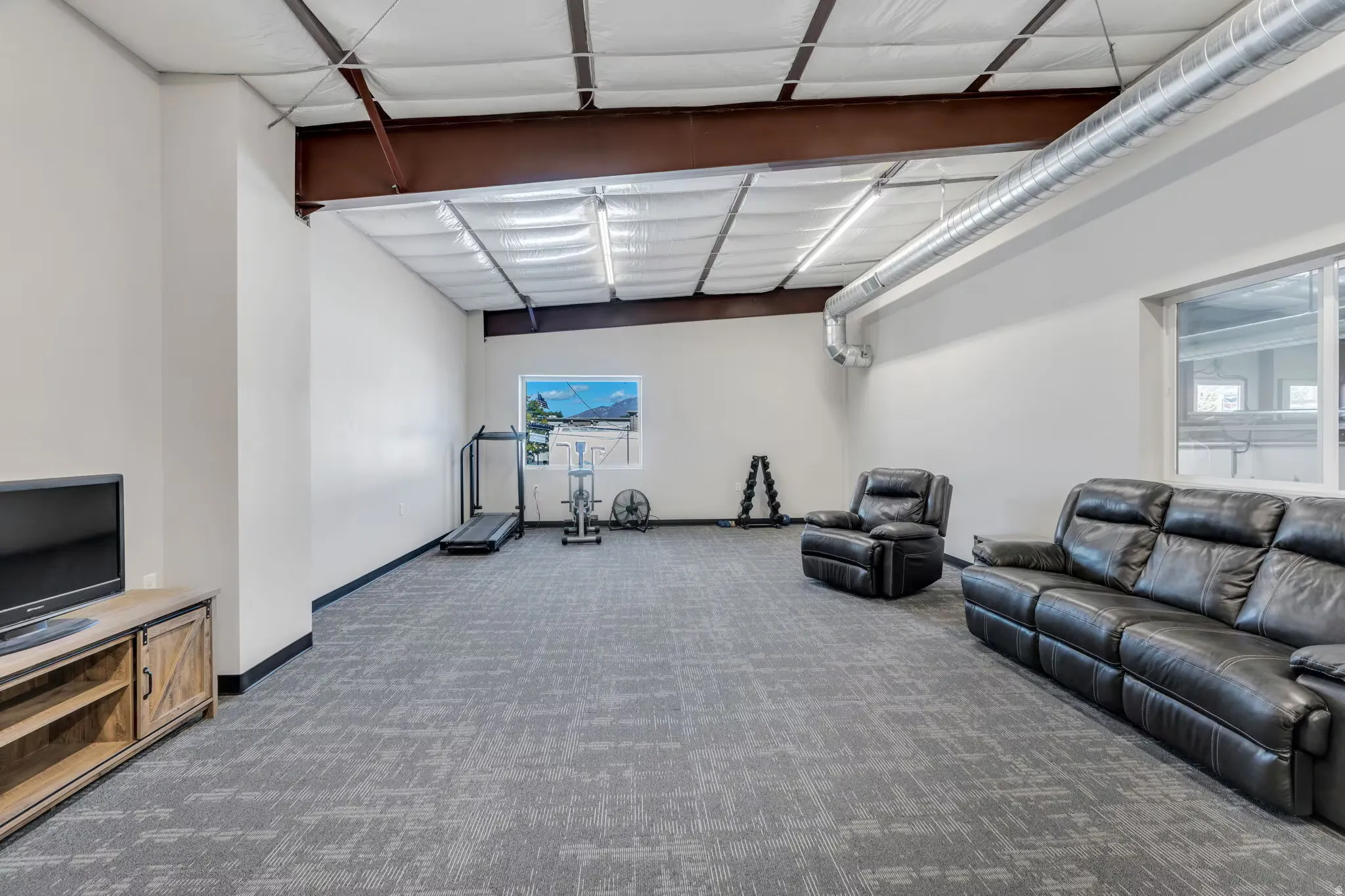 Carpeted living area featuring baseboards