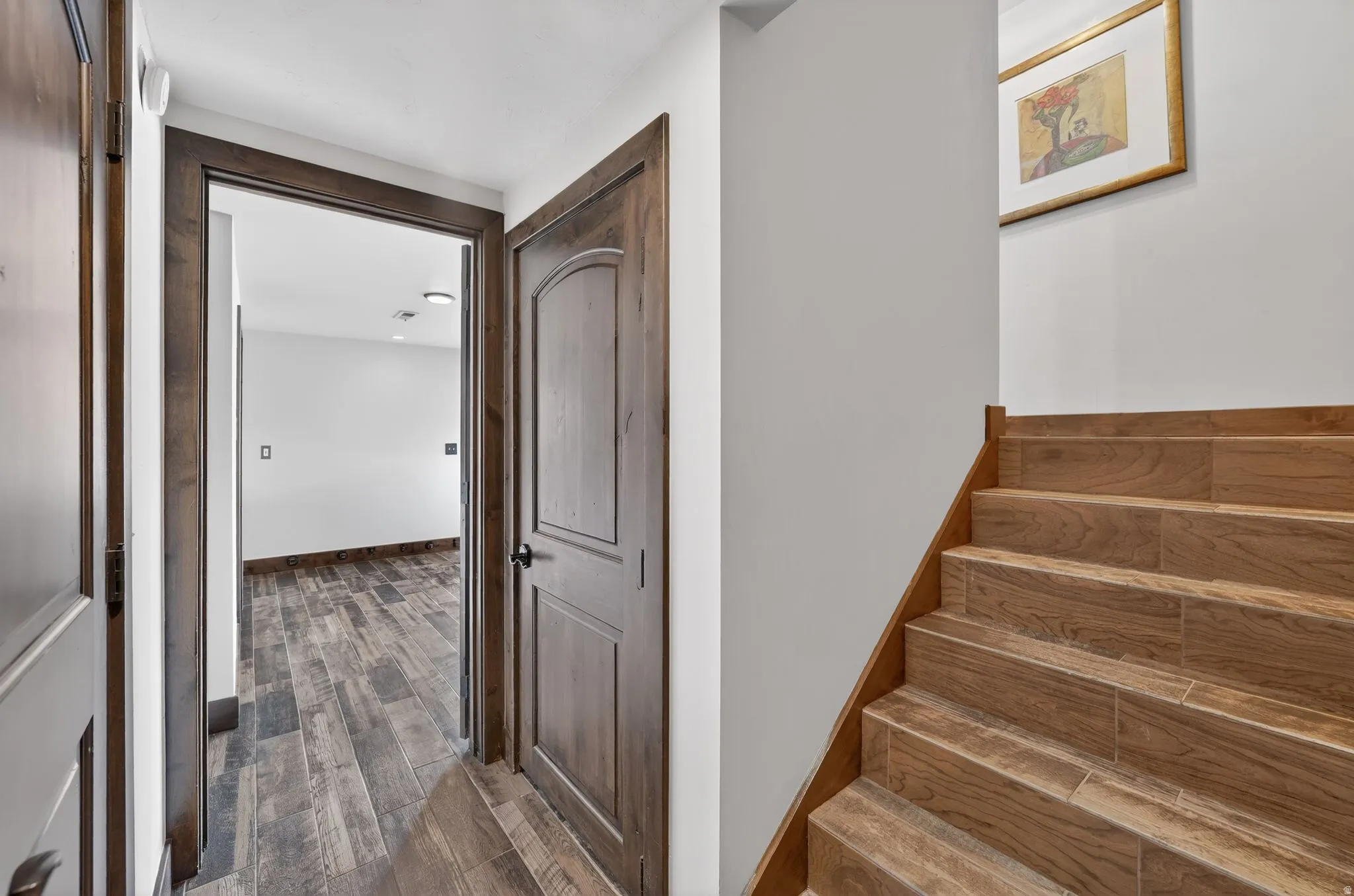 Staircase with wood finished floors and baseboards