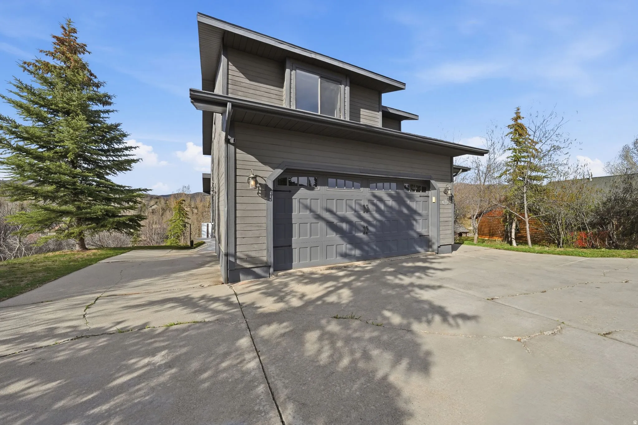 View of side of home featuring concrete driveway and a garage